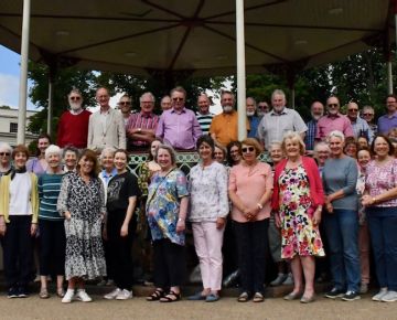 Choir members relax by the bandstand after the afternoon rehearsal